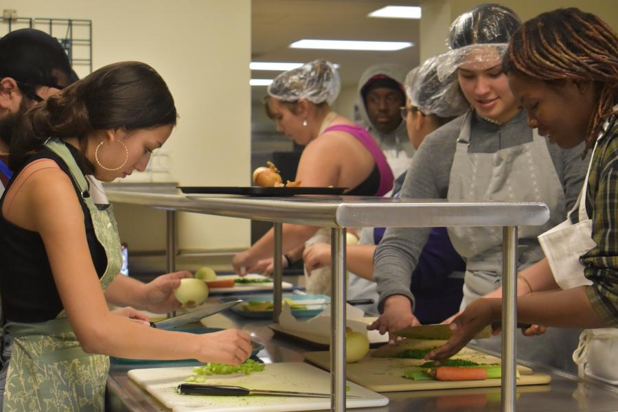 A group of students chopping vegetables